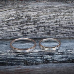 hochzeitsfotograf zeigt bicolor eheringe auf holz