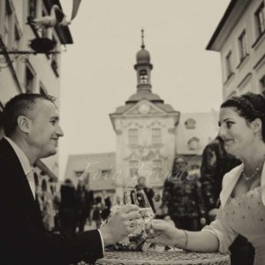 hochzeitsbild vor altem rathaus in bamberg brautpaar stösst mit sekt an