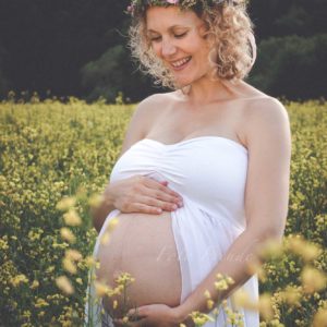 schwangere mit blumenkranz im rapsfeld in hirschaid bei babybauchshooting