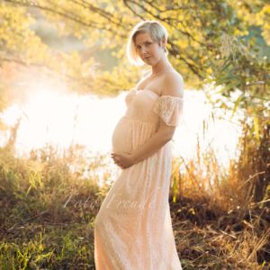 schwangere bei babybauchshooting im sonnenuntergang im spitzenkleid am see in hallstadt