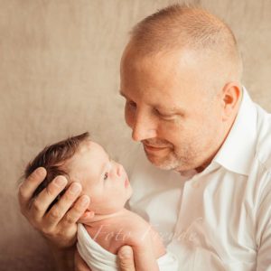 vater und baby bei neugeborenenshooting daheim neutral und gefuehlvoll bei forchheim